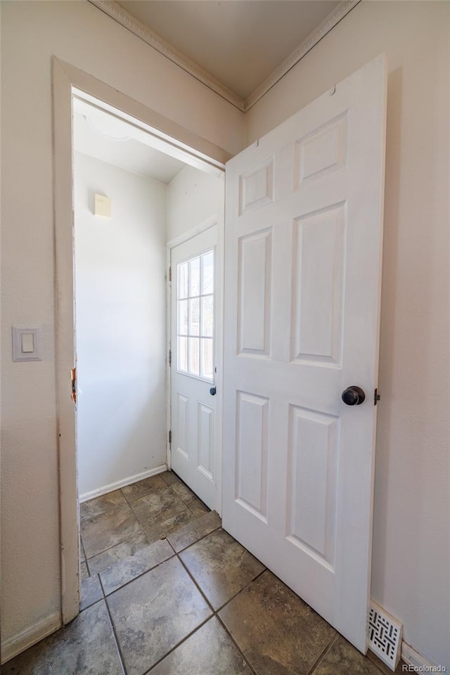 doorway featuring baseboards and stone finish flooring