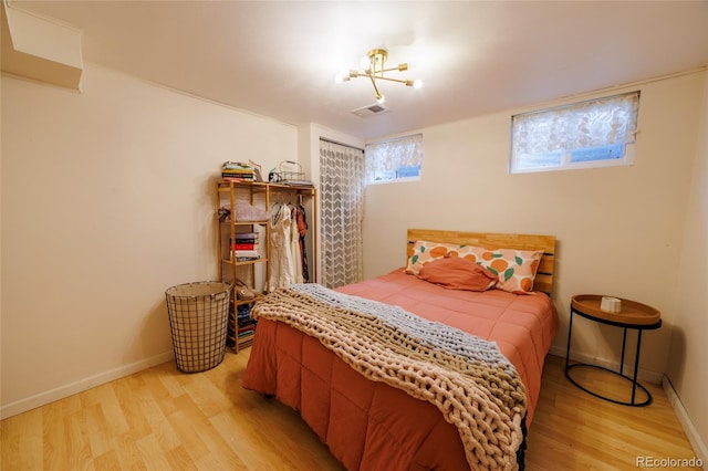 bedroom featuring baseboards, visible vents, and light wood-style flooring
