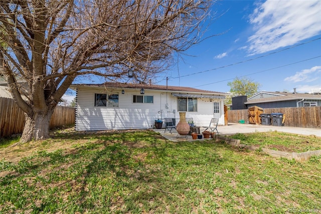 back of house featuring a lawn, a patio, and a fenced backyard