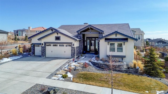 view of front of home featuring a residential view, a tile roof, driveway, and an attached garage