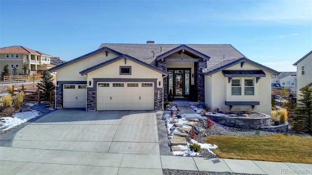 view of front of house with a garage, a tiled roof, concrete driveway, and stucco siding