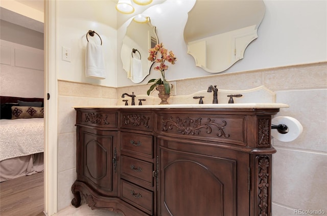 5215 S Washington St, Littleton, CO 80121 - ensuite bathroom featuring double vanity, tile walls, and wainscoting