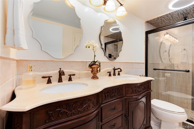 5215 S Washington St, Littleton, CO 80121 - bathroom with double vanity, a tile shower, a wainscoted wall, and tile walls