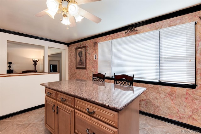 5215 S Washington St, Littleton, CO 80121 - kitchen featuring ceiling fan, light tile patterned floors, a center island, ornamental molding, and stone counters