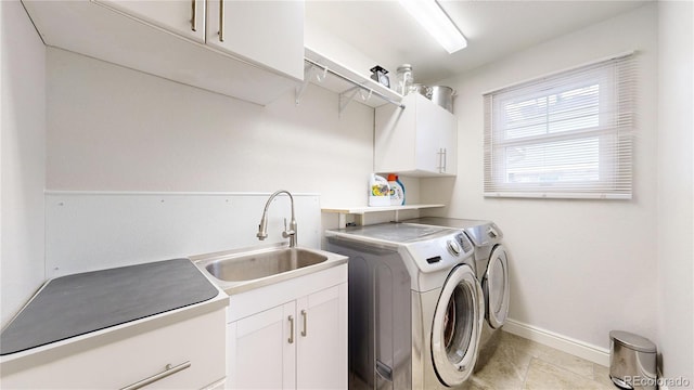 washroom featuring sink, washer and clothes dryer, and cabinets