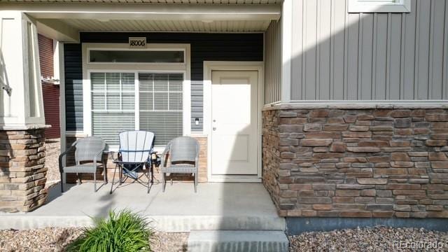 18006 E 103rd Ave, Commerce City, CO 80022 - doorway to property featuring a porch and board and batten siding