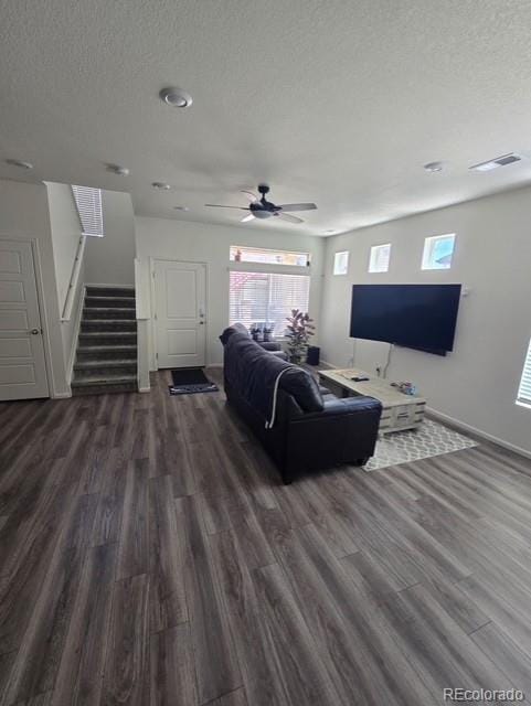 18006 E 103rd Ave, Commerce City, CO 80022 - living area with a textured ceiling, dark wood-type flooring, stairs, baseboards, and ceiling fan