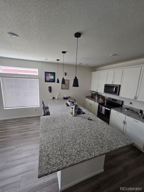 18006 E 103rd Ave, Commerce City, CO 80022 - kitchen with stainless steel appliances, a textured ceiling, white cabinets, a sink, and light wood-type flooring