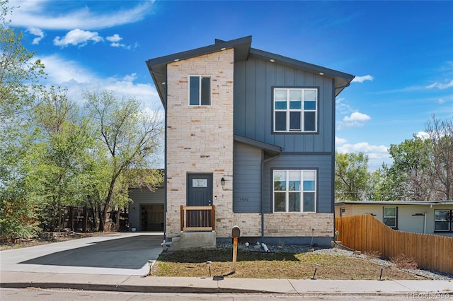 5470 Krameria St, Commerce City, CO 80022 - contemporary house featuring board and batten siding, fence, stone siding, and driveway