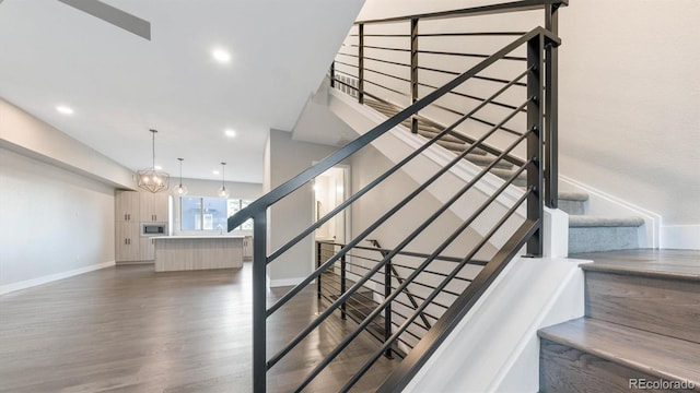 staircase featuring a notable chandelier and hardwood / wood-style floors