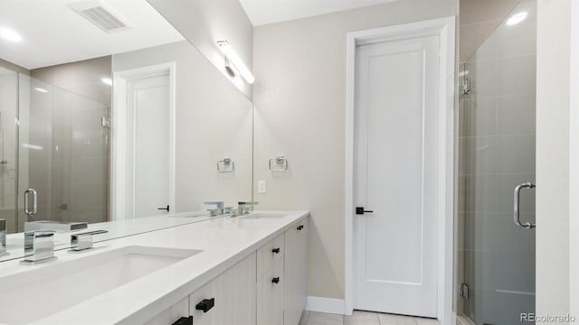 bathroom featuring tile patterned flooring, walk in shower, and vanity