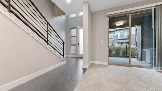 tiled entrance foyer with a healthy amount of sunlight