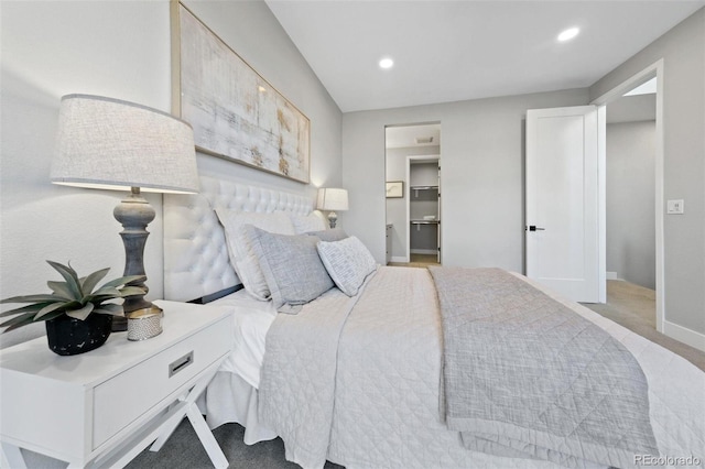 bedroom featuring a spacious closet and light carpet