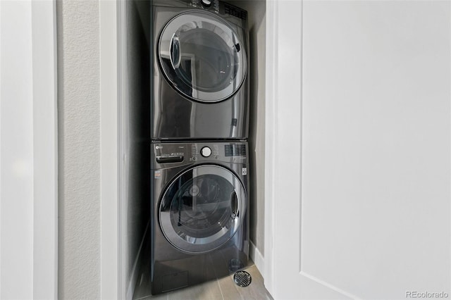 clothes washing area with stacked washer / dryer