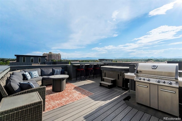 wooden deck featuring a mountain view, an outdoor hangout area, and grilling area