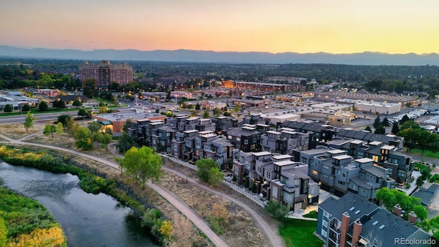 aerial view at dusk featuring a water view