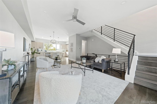 living room with ceiling fan and dark hardwood / wood-style flooring