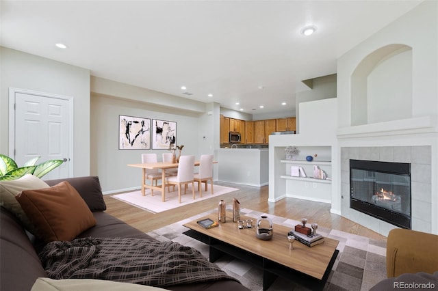 living room featuring light hardwood / wood-style floors and a tile fireplace