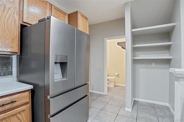 kitchen featuring stainless steel refrigerator with ice dispenser, tasteful backsplash, and light tile patterned floors