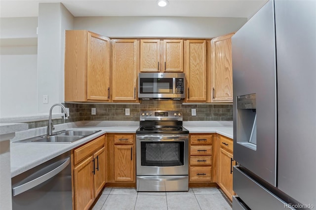 kitchen featuring decorative backsplash, sink, light tile patterned floors, and appliances with stainless steel finishes