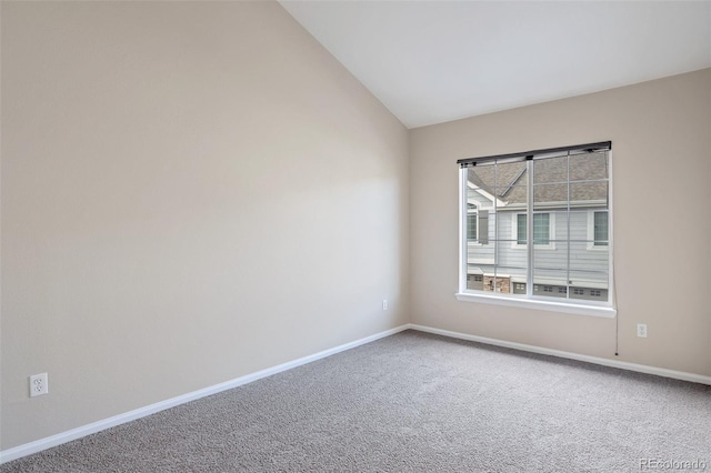 carpeted empty room featuring lofted ceiling