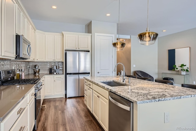 268 Simmental Loop, Castle Rock, CO 80104 - kitchen featuring appliances with stainless steel finishes, recessed lighting, dark wood-style flooring, light stone counters, and tasteful backsplash