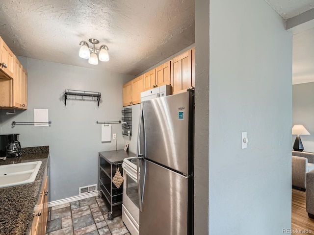 kitchen featuring sink, electric range, stainless steel fridge, and light brown cabinets