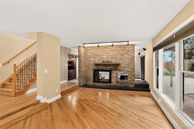 6338 S Oneida Ct, Centennial, CO 80111 - unfurnished living room with track lighting, wood finished floors, a fireplace, and stairs