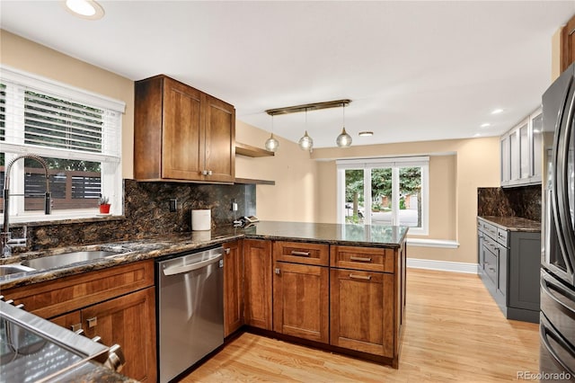 6338 S Oneida Ct, Centennial, CO 80111 - kitchen with appliances with stainless steel finishes, a peninsula, light wood-type flooring, decorative backsplash, and recessed lighting