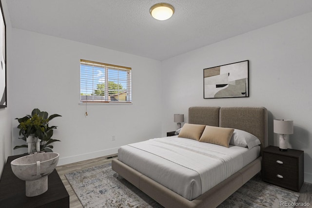 8381 Vine St, Denver, CO 80229 - bedroom featuring wood finished floors and a textured ceiling