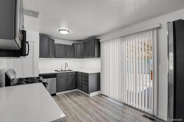 8381 Vine St, Denver, CO 80229 - kitchen featuring stainless steel dishwasher, light countertops, light wood finished floors, and range with gas cooktop