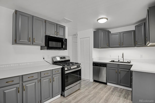 8381 Vine St, Denver, CO 80229 - kitchen with appliances with stainless steel finishes, light countertops, light wood-type flooring, and gray cabinets