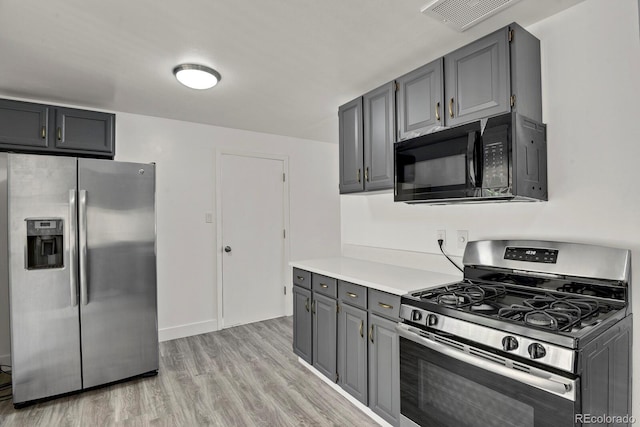 8381 Vine St, Denver, CO 80229 - kitchen featuring appliances with stainless steel finishes, gray cabinetry, light wood finished floors, and light countertops