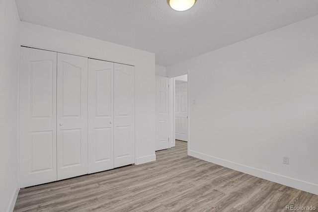 8381 Vine St, Denver, CO 80229 - unfurnished bedroom with light wood-style flooring, a closet, and a textured ceiling