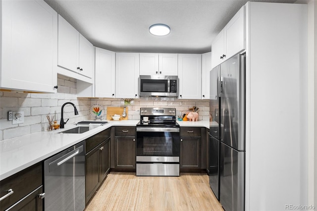 495 S Dayton St Unit 1C, Denver, CO 80247 - kitchen featuring light countertops, a sink, white cabinets, and stainless steel appliances