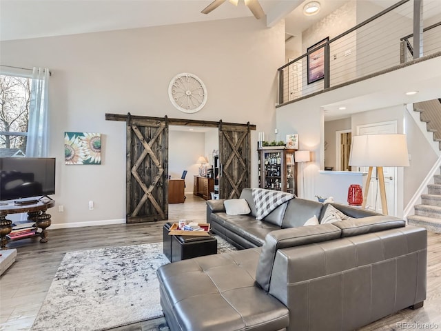 8862 Chestnut Hill Ln, Highlands Ranch, CO 80130 - living area with a barn door, wood finished floors, baseboards, stairs, and a ceiling fan