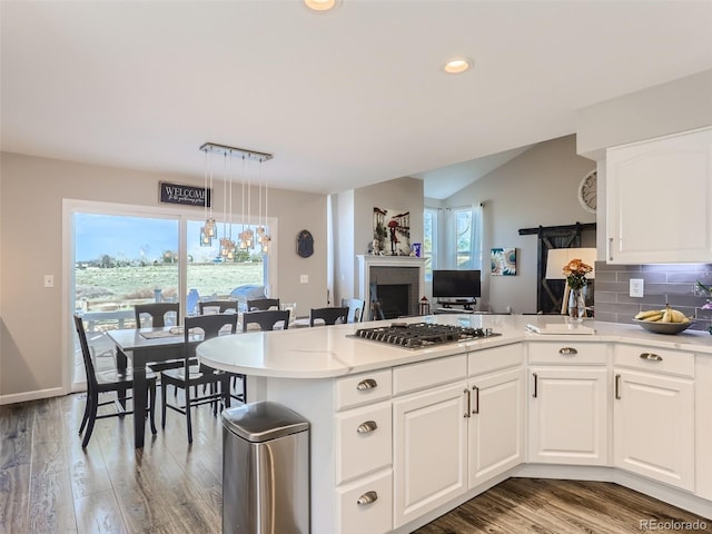 8862 Chestnut Hill Ln, Highlands Ranch, CO 80130 - kitchen featuring stainless steel gas cooktop, light wood-style floors, white cabinets, tasteful backsplash, and recessed lighting