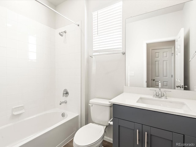 full bathroom featuring vanity, tiled shower / bath, and toilet