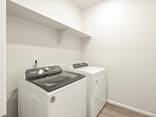 laundry room featuring washer and dryer and light hardwood / wood-style flooring