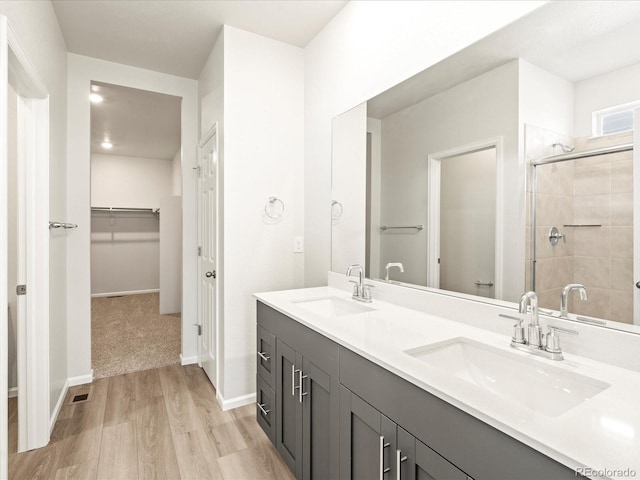 bathroom featuring wood-type flooring, toilet, a shower with door, and vanity