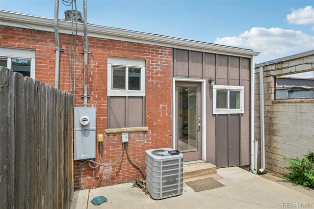 3444 Lawrence St, Denver, CO 80205 - property entrance with board and batten siding, central AC unit, and brick siding