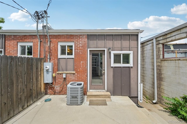 3444 Lawrence St, Denver, CO 80205 - back of house with board and batten siding, cooling unit, a patio, and brick siding