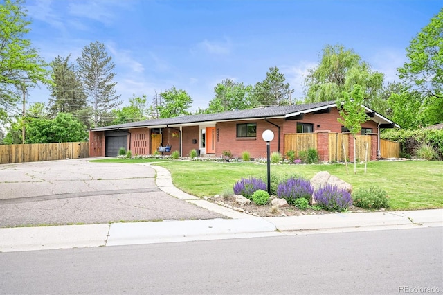 5200 W Rowland Ave, Littleton, CO 80128 - ranch-style house with an attached garage, driveway, and brick siding