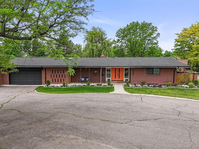5200 W Rowland Ave, Littleton, CO 80128 - ranch-style house featuring brick siding, an attached garage, a front yard, and driveway