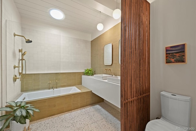 5200 W Rowland Ave, Littleton, CO 80128 - bathroom with tile walls, tiled tub, toilet, a sink, and tiled shower