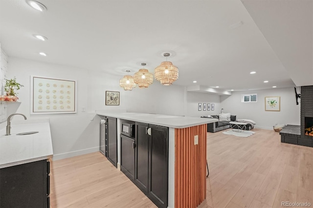 5200 W Rowland Ave, Littleton, CO 80128 - kitchen with a sink, a peninsula, open floor plan, light wood-style floors, and recessed lighting