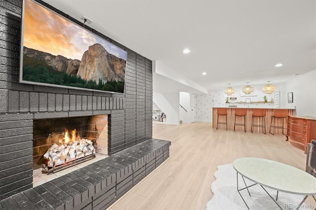 5200 W Rowland Ave, Littleton, CO 80128 - living room with wood finished floors, a fireplace, stairs, recessed lighting, and bar area