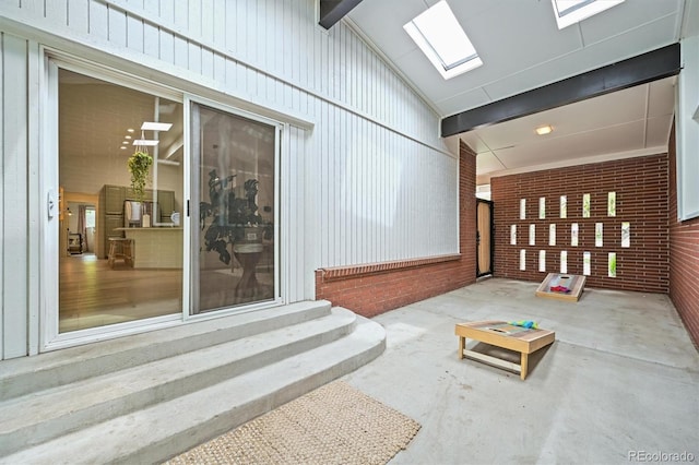 5200 W Rowland Ave, Littleton, CO 80128 - common area featuring brick wall and vaulted ceiling