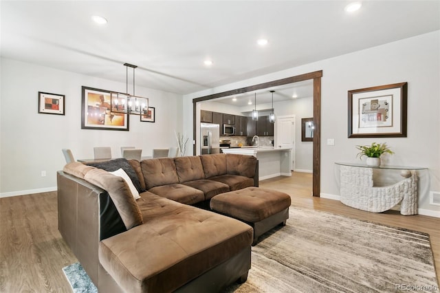 living area with light wood-style flooring, recessed lighting, and baseboards