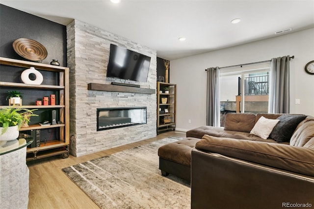 living area with recessed lighting, visible vents, wood finished floors, and a fireplace